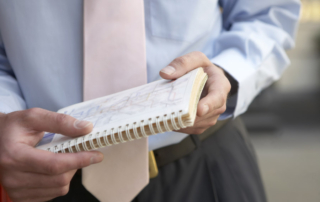 Photo of two people strategizing with a notebook